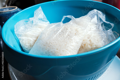 Cooked rice in a bag placed in a blue colander
