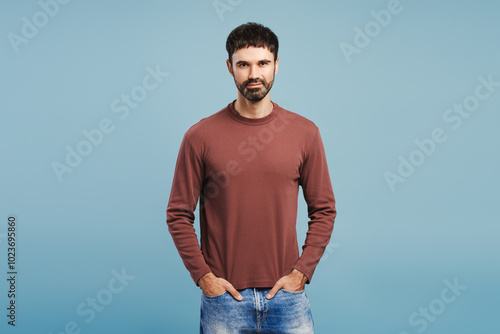 Handsome attractive man wearing stylish sweater with hands pocket posing isolated on blue background