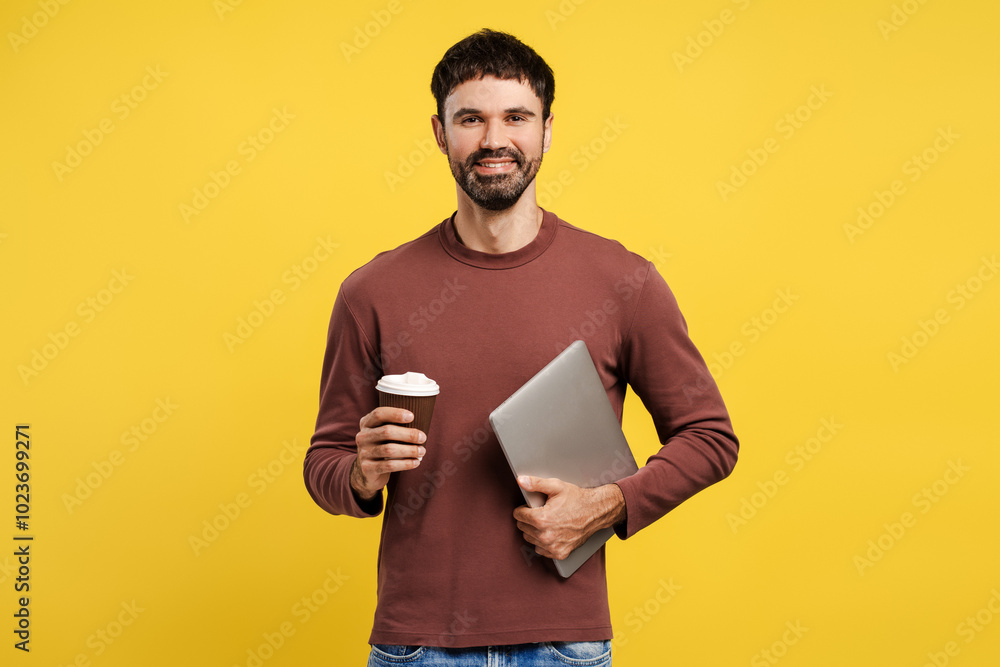 Portrait of smiling, attractive bearded hispanic man holding laptop and paper cup with coffee Portrait of smiling, attractive bearded hispanic man holding laptop and paper cup with coffee