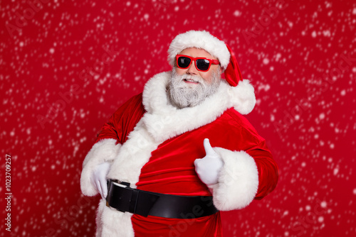 Fotografía Portrait of attractive cheerful Santa showing thumbup advert ad recommend isolat