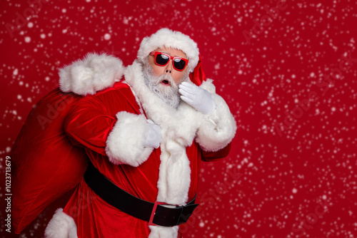 Photo of excited crazy retired man carry big bag gifts wow reaction wear santa hat costume isolated red color background