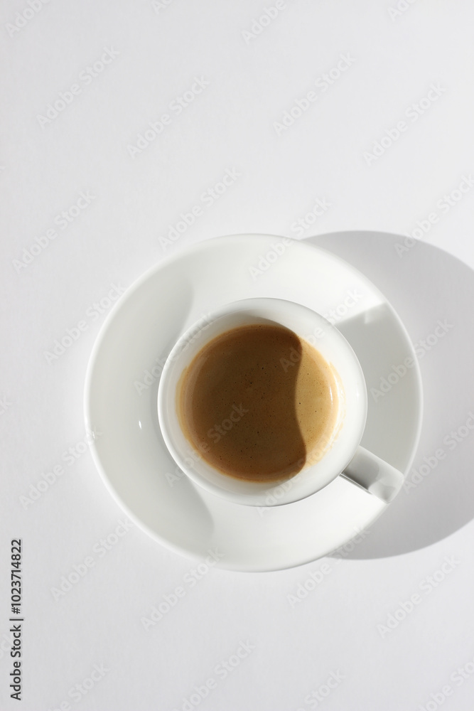 Espresso Coffee with Crema Foam Top View. Freshly Brewed Coffee in White Cup on White Background. Espresso Coffee with Crema Foam Top View. Freshly Brewed Coffee in White Cup on White Background.