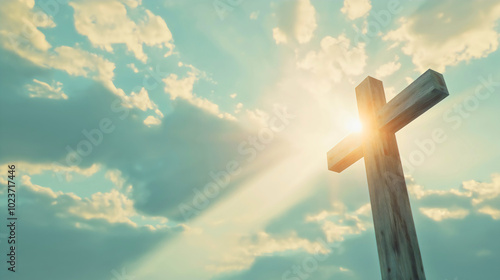 A cross behind which the sun breaks through the clouds, symbolizing struggle and victory, a wooden cross standing upright.