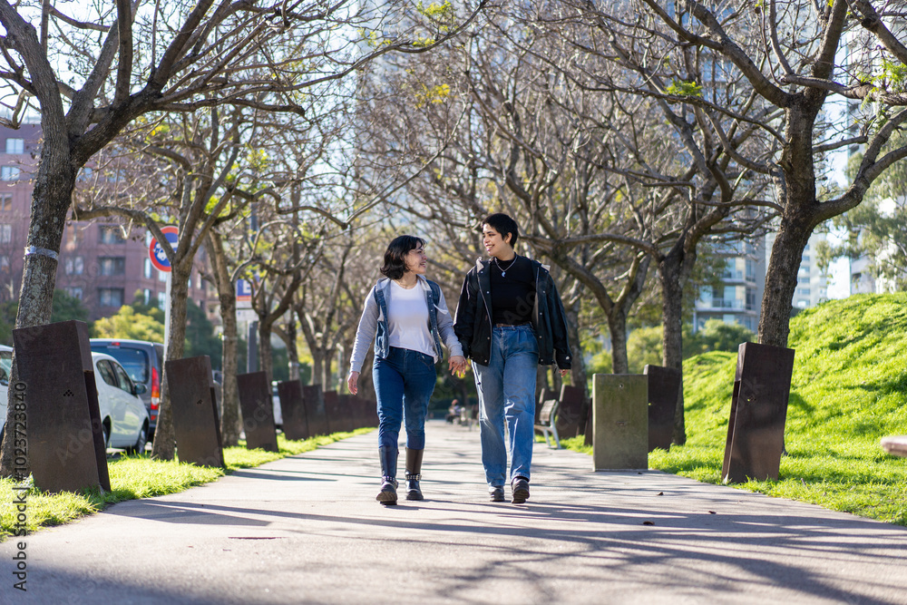 Lesbian couple walking hand-in-hand in Buenos Aires park Lesbian couple walking hand-in-hand in Buenos Aires park