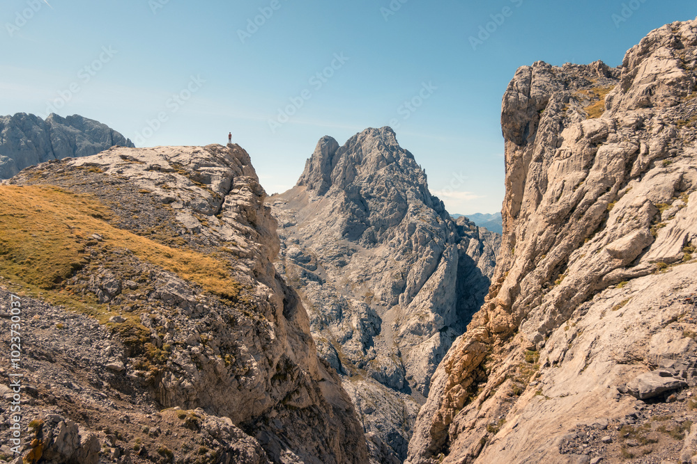 Lone hiker stands atop rugged peak in Picos de Europa Lone hiker stands atop rugged peak in Picos de Europa