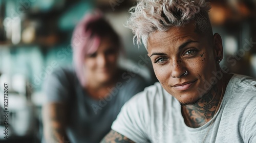 A tattooed woman with pink hair smiles warmly in a vibrant café. Surrounded by cozy decor, she conveys positivity and individuality in a modern urban setting.