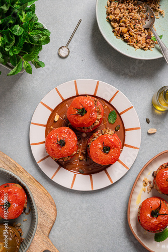 Roasted stuffed tomatoes with brown rice and nuts on ceramic plates photo