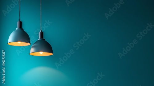 Stylish pendant lamps hanging against a vibrant teal wall, providing soft illumination and modern ambiance.