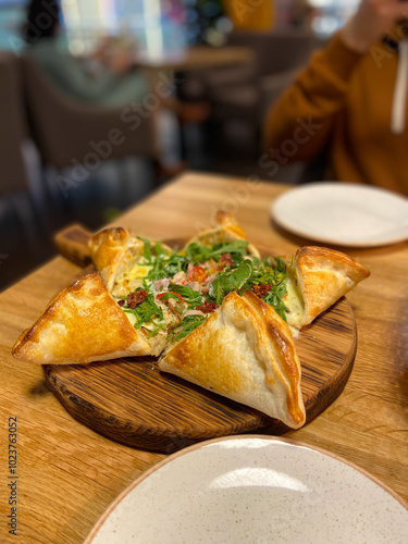 Deliciously presented dish features a unique pastry filled with fresh ingredients, inviting taste and flavor. Culinary creativity on a rustic wooden board, perfect for sharing