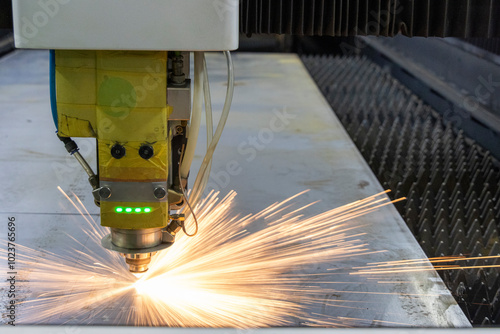 A laser cutting table in action, creating precise metal designs in a metal fabrication shop