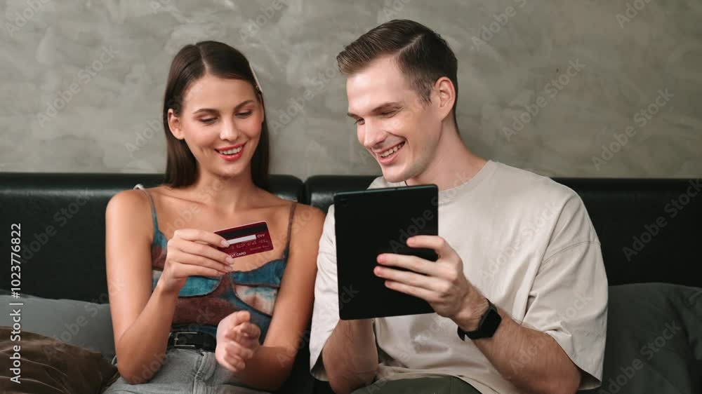 Young couple sit in the home bedroom using online payment app and digital wallet on tablet to pay with credit card. E commerce shopping and modern purchasing via mobile internet. Adit Young couple sit in the home bedroom using online payment app and digital wallet on tablet to pay with credit card. E commerce shopping and modern purchasing via mobile internet. Adit