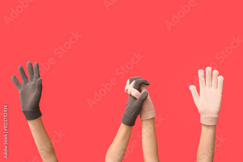 Hands in warm gloves on red background