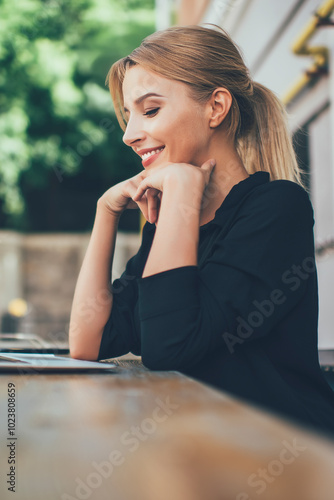 Side view of happy hipster girl watching positive comedy movie on content website connected to public wifi on laptop device, positive female blogger enjoying online video chatting with followers