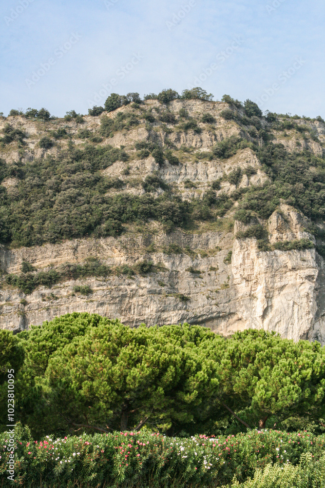 Mountain cliff with green bushes and blue sky, Italy Mountain cliff with green bushes and blue sky, Italy