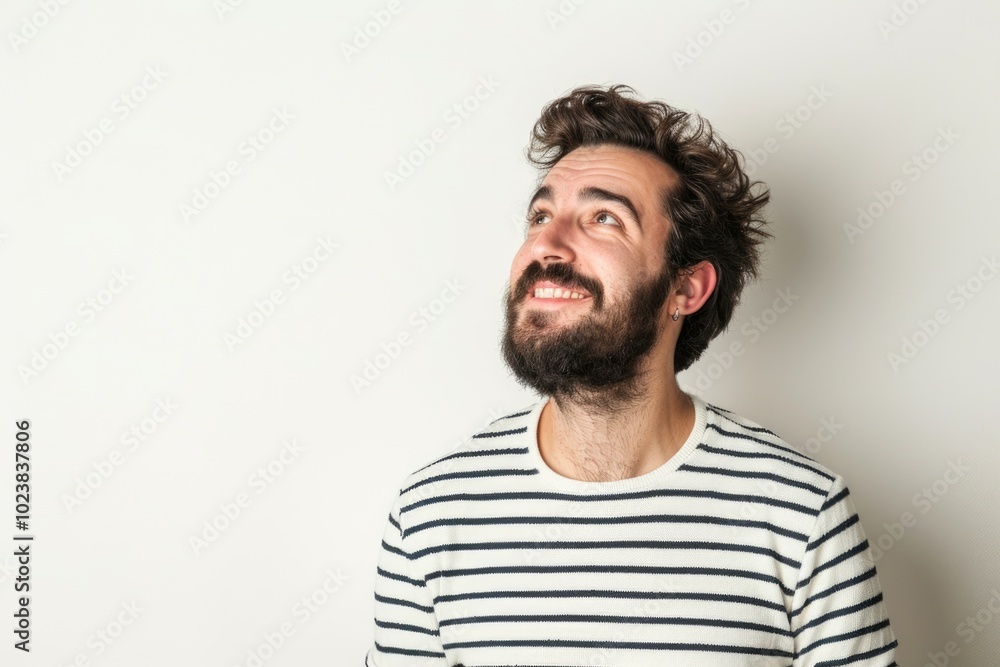 Obraz premium Handsome man in striped shirt smiling and thinking.