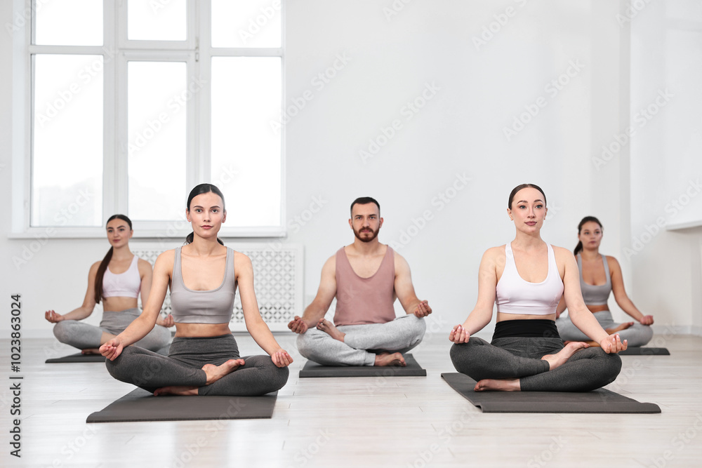 Group of people meditating on mats in yoga class Group of people meditating on mats in yoga class