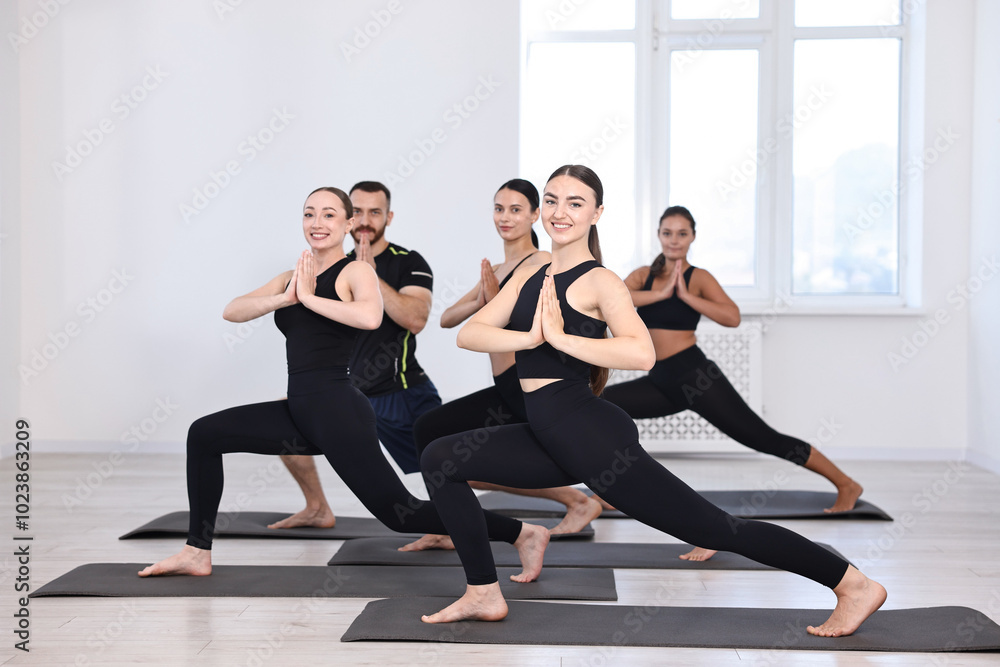 Group of people practicing yoga on mats in class Group of people practicing yoga on mats in class
