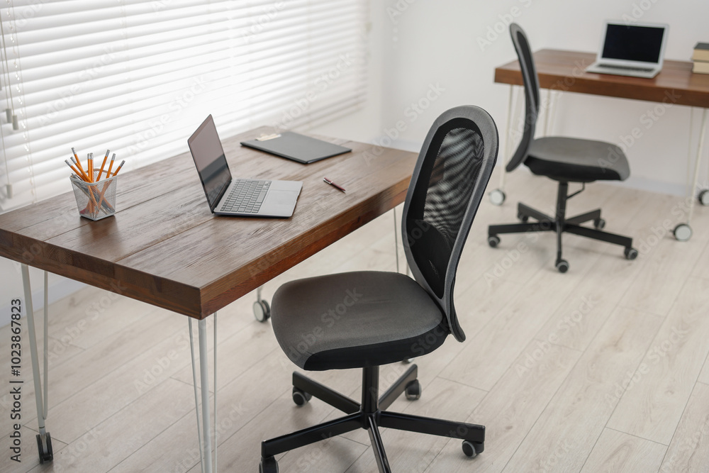Black chair, laptop and desk in office Black chair, laptop and desk in office