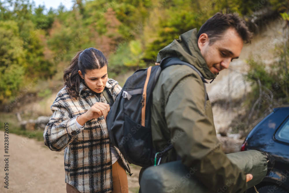Girlfriend help boyfriend to pack and fasten his backpack Girlfriend help boyfriend to pack and fasten his backpack
