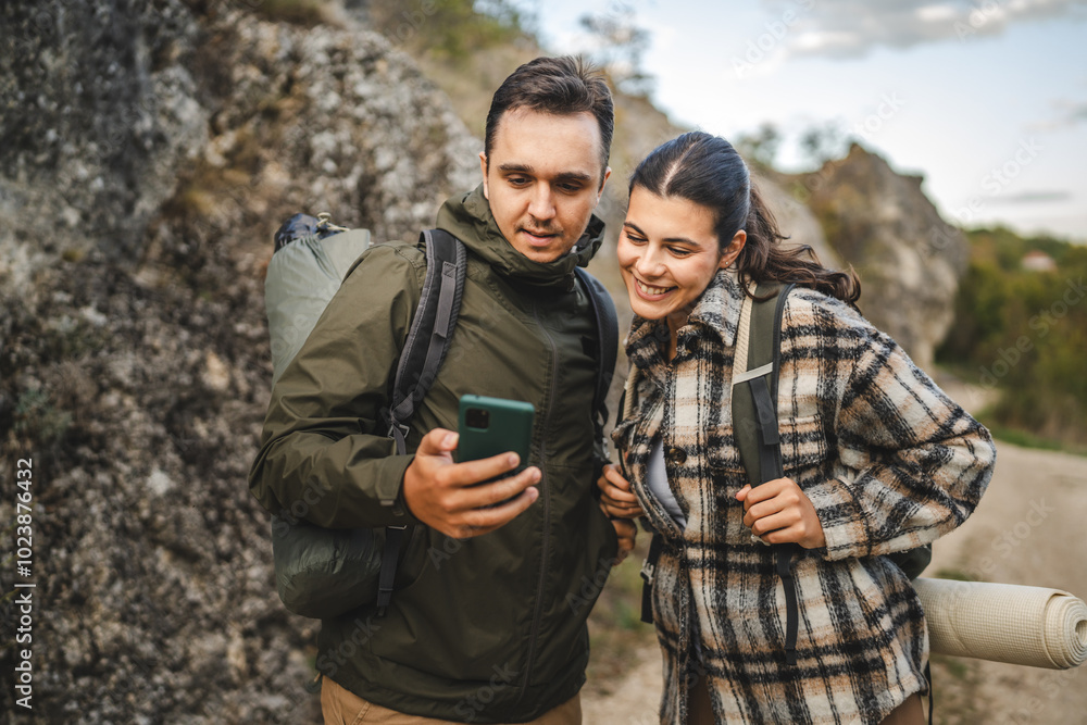 Boyfriend and girlfriend hikers explore forest with mobile phone Boyfriend and girlfriend hikers explore forest with mobile phone