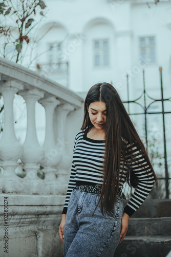 Stylish woman by metal fence in the city