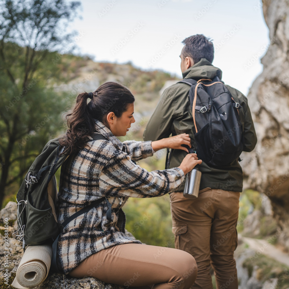 Girlfriend help boyfriend to pack and fasten his backpack Girlfriend help boyfriend to pack and fasten his backpack