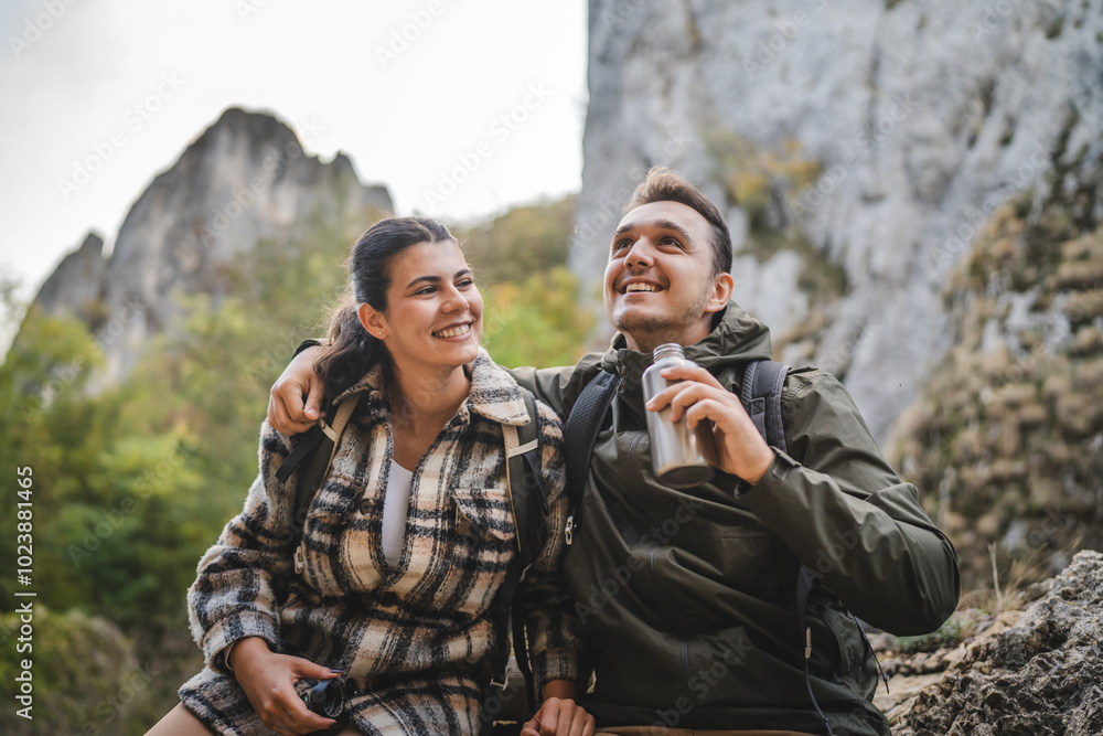 Boyfriend and girlfriend hikers rest from hiking and drink water Boyfriend and girlfriend hikers rest from hiking and drink water