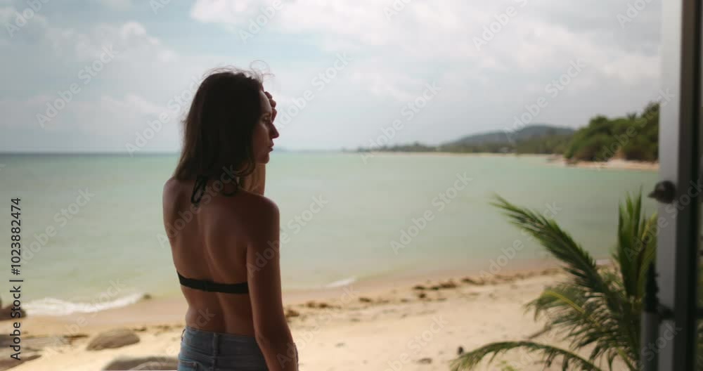Young woman is enjoying the view from a terrace overlooking a beautiful beach in thailand. The video has a slow motion effect Young woman is enjoying the view from a terrace overlooking a beautiful beach in thailand. The video has a slow motion effect