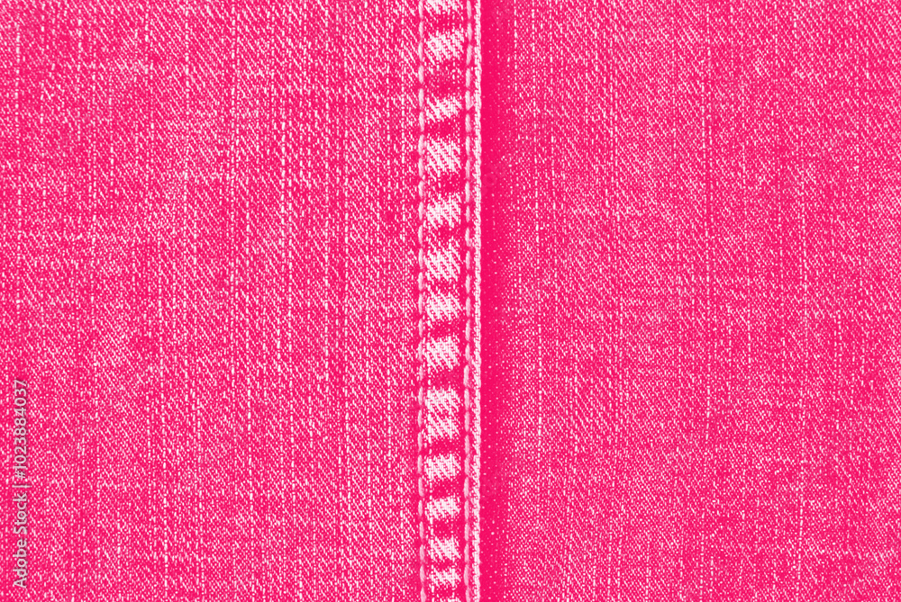 Pink denim texture, a detail of seamed jeans pants with a stitch in the center Pink denim texture, a detail of seamed jeans pants with a stitch in the center