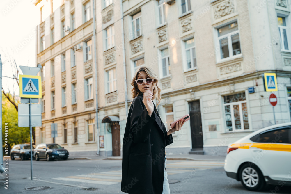 A woman walks down the street talking on a cell phone A woman walks down the street talking on a cell phone