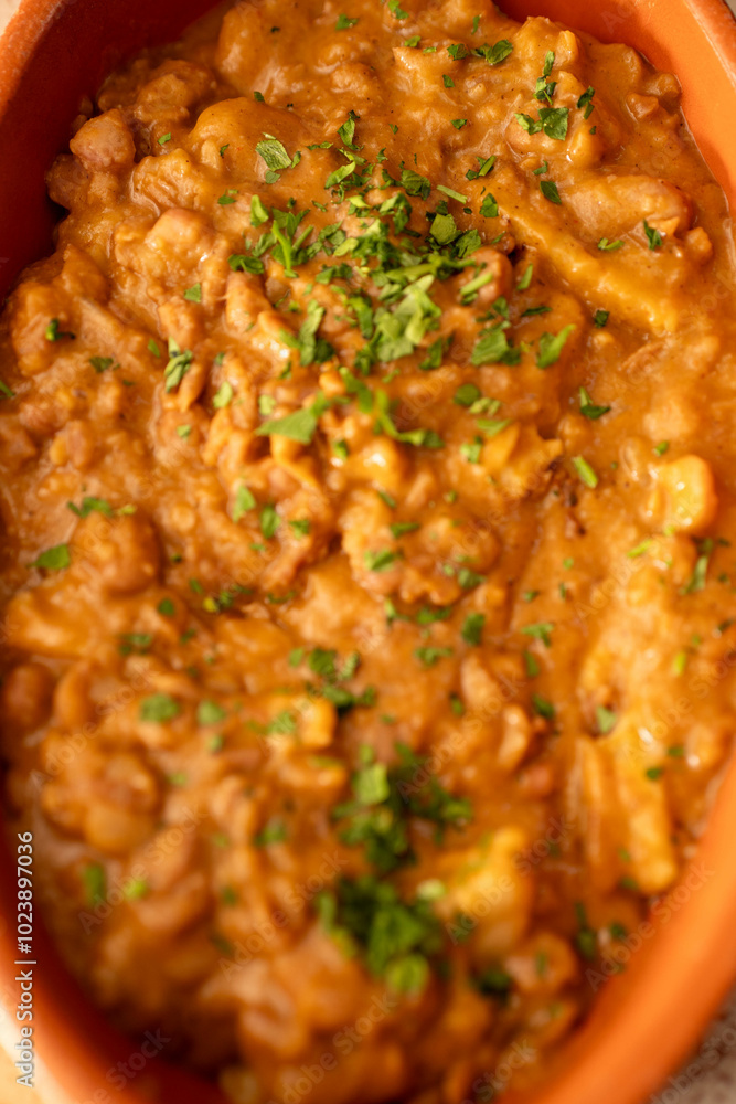 A bowl of lentil stew garnished with fresh herbs. Ideal for food blogs, vegan menus, or articles focusing on hearty, plant-based meals perfect for cooler seasons. A bowl of lentil stew garnished with fresh herbs. Ideal for food blogs, vegan menus, or articles focusing on hearty, plant-based meals perfect for cooler seasons.