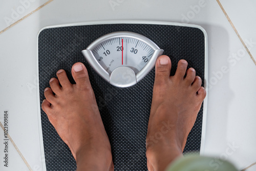 Person Weighing on Bathroom Scale photo