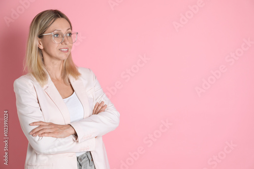 Beautiful smiling woman in glasses on pink background, space for text