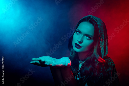 Photo of tempting lady in witch costume hold hands demonstrate copyspace for advertising isolated neon mist background