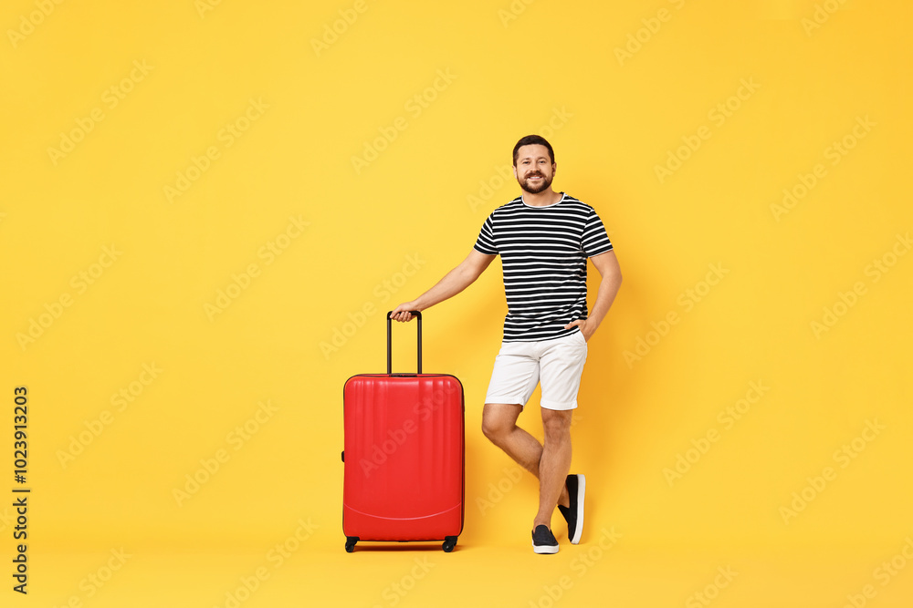 Happy man with suitcase on orange background Happy man with suitcase on orange background