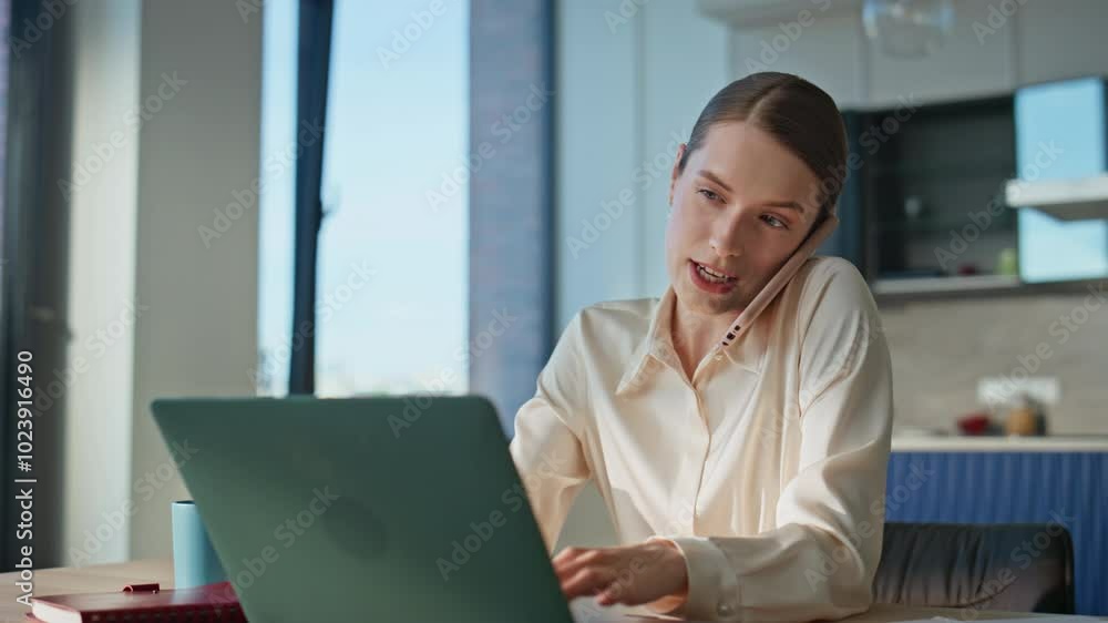 Professional woman speaking cellphone typing on laptop at home office closeup. Professional woman speaking cellphone typing on laptop at home office closeup.