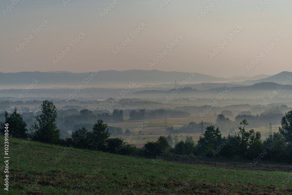 View of small mountains shrouded in morning fog. View of small mountains shrouded in morning fog.