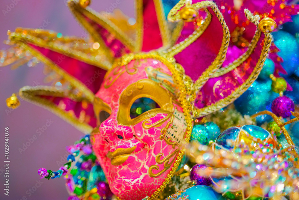 Naklejka premium Carnival bright mask on a purple background.Carnival background with masks, feathers and glitter.