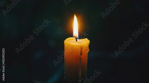 Burning black candle on a dark background. Symbol of mourning, grief, solemnity