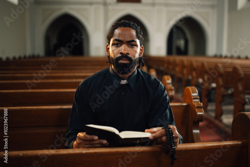 Obraz na plátně Priest sitting in church pew reading holy bible