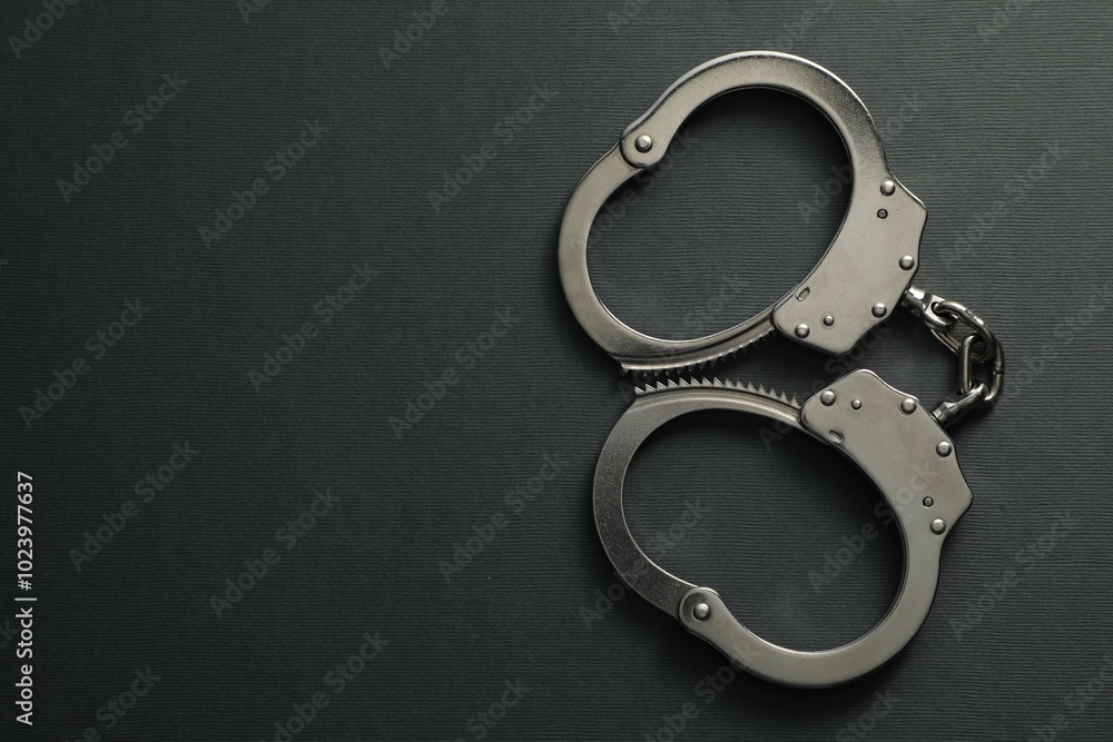 Classic chain handcuffs on black background, top view. Space for text Classic chain handcuffs on black background, top view. Space for text