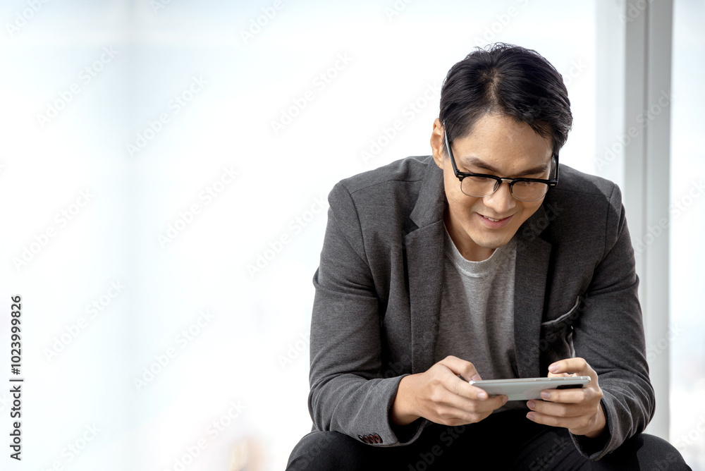 Young businessman, interesting, holding a smartphone, expressing his joy in his success, the concept of businessman and technology. Young businessman, interesting, holding a smartphone, expressing his joy in his success, the concept of businessman and technology.