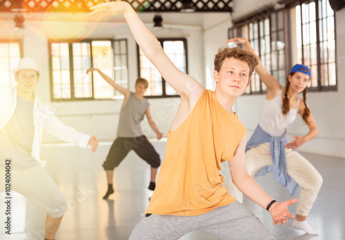 Team of young dancers training street dance moves and having fun photo