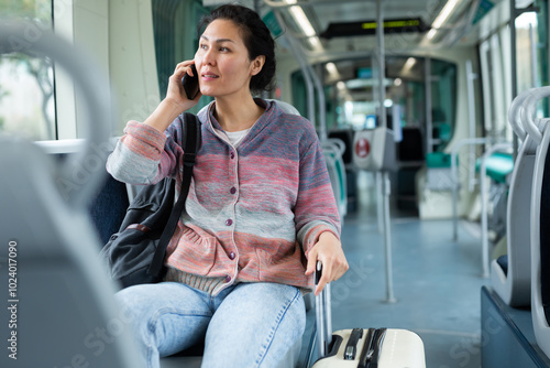 Oriental woman talking on a mobile phone while riding a tram photo