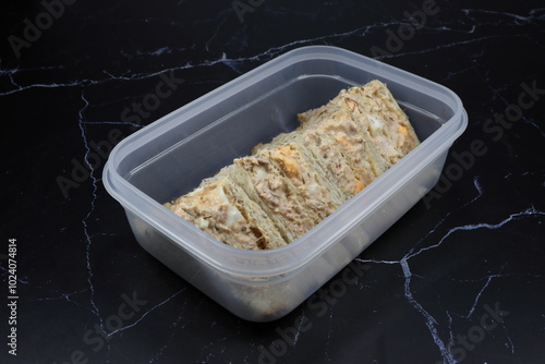Pile of fresh and organic tuna and egg sandwich serving in the plastic box. Famous quick and easy breakfast menu in Asia. 