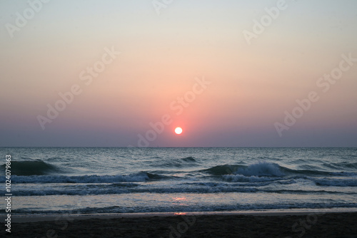 solo albeggia in una spiaggia sabbiosa  photo