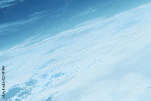 An abstract aerial view of clouds, with soft, wispy textures and a blue sky above.