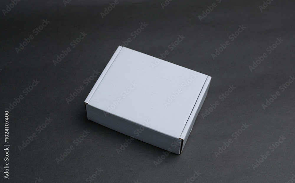 A white box is laying flat on a dark surface A white box is laying flat on a dark surface