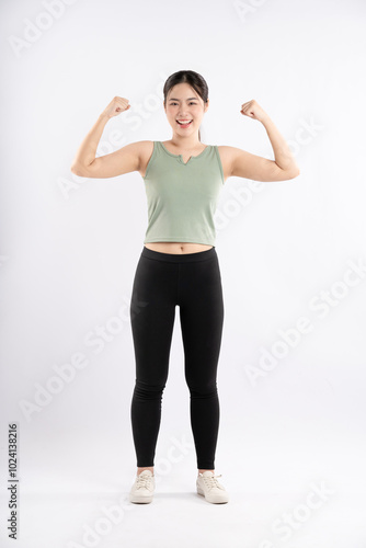 Full body image of young Asian girl wearing sports outfit and posing on white background