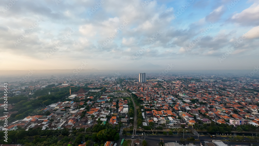 Obraz premium A cityscape with a cloudy sky and tall buildings